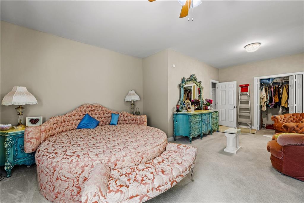 915 Magnolia Way Hampton, GA 30228 - Photo 38 of 68 a bedroom with a bed a couch and a chandelier