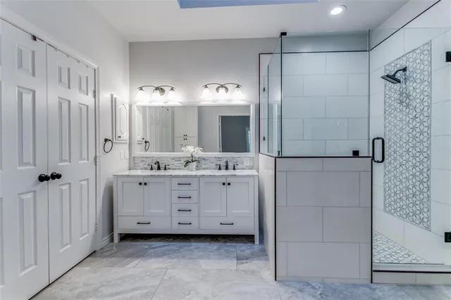 a bathroom with a double vanity sink mirror and shower