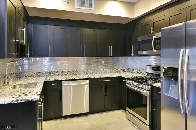 a kitchen with stainless steel appliances granite countertop a stove sink and cabinets