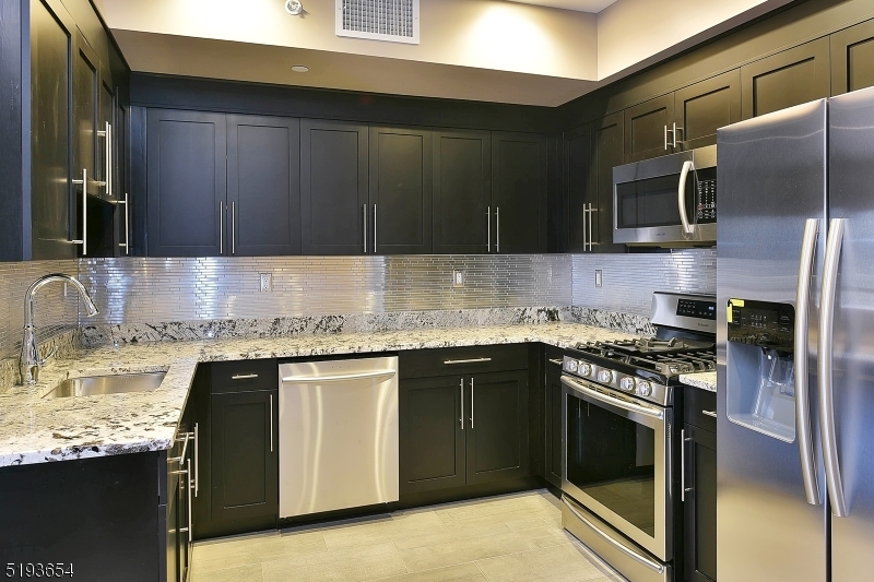 8 Whitehall Road, Unit 3 Montville, NJ 07082 - Photo 4 of 13 a kitchen with stainless steel appliances granite countertop a stove sink and cabinets