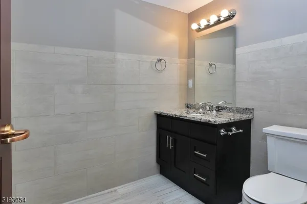 a bathroom with a toilet a sink and mirror