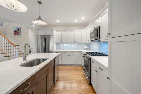 a kitchen with kitchen island granite countertop a sink and refrigerator