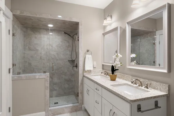 a bathroom with a double vanity sink mirror and shower
