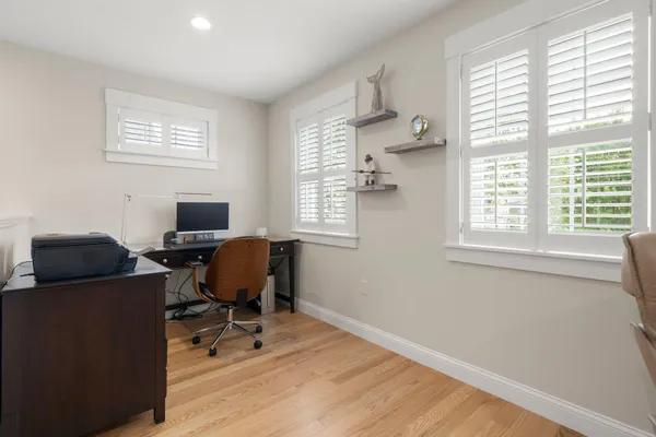 a view of a workspace with furniture and a window