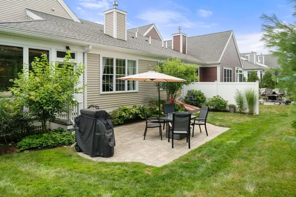 a view of a house with a yard and sitting area