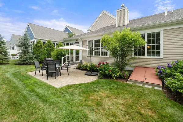 a front view of a house with garden and sitting area