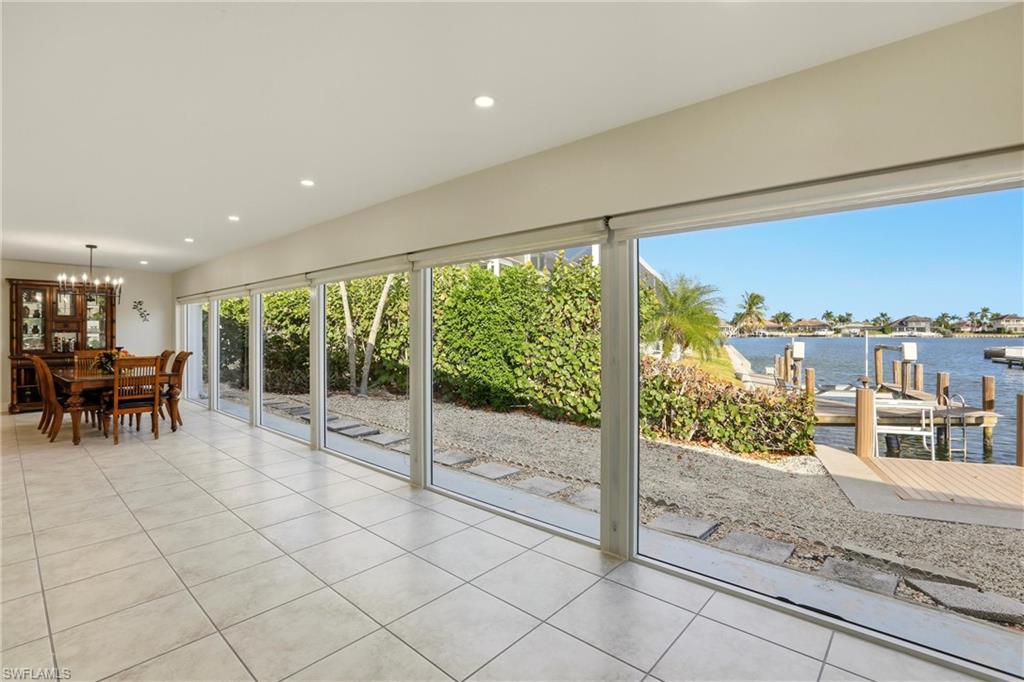339 Landmark Street Marco Island, FL 34145 - Photo 29 of 50 Sunroom / solarium featuring a water view and a chandelier