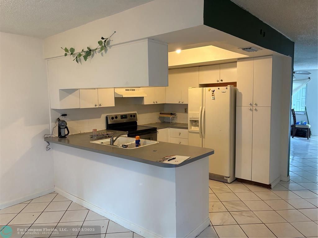 7659 Northwest 74th Avenue Tamarac, FL 33321 - Photo 4 of 11 a kitchen with sink cabinets and refrigerator
