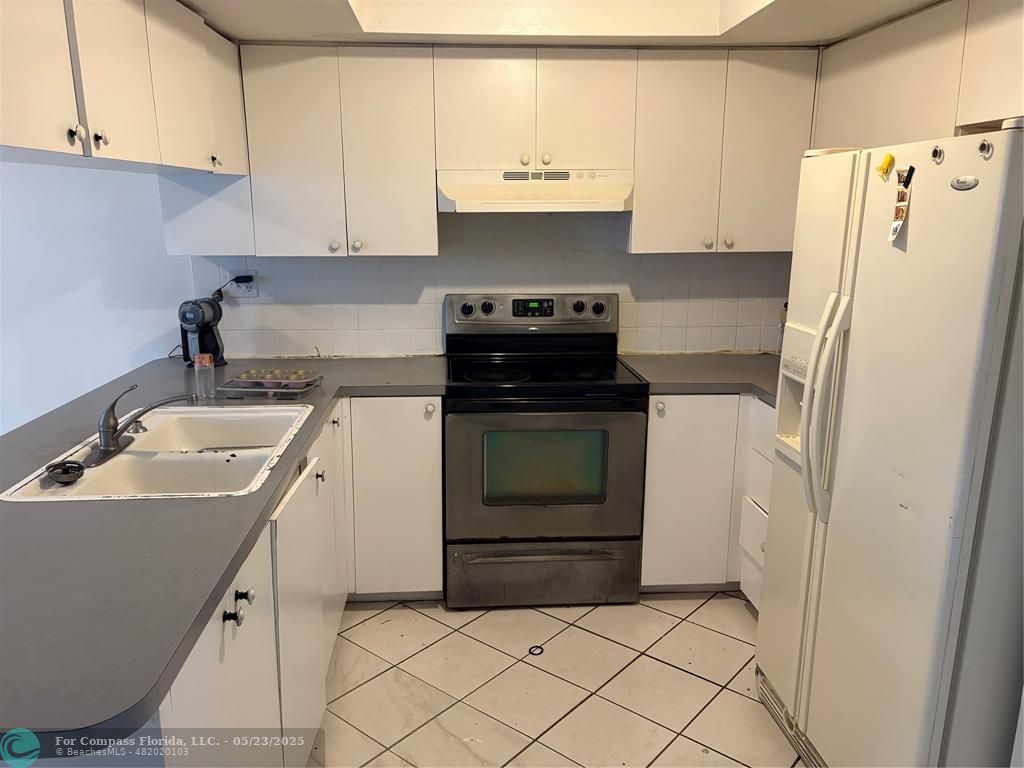 7659 Northwest 74th Avenue Tamarac, FL 33321 - Photo 5 of 11 a kitchen with a sink stove and refrigerator