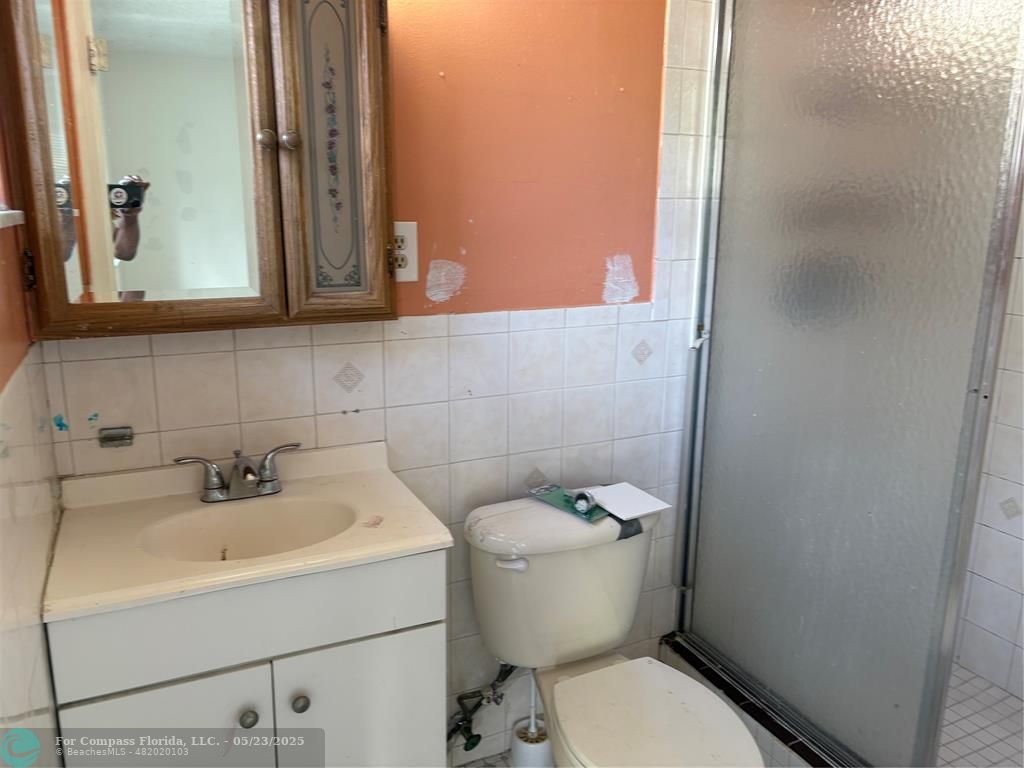 7659 Northwest 74th Avenue Tamarac, FL 33321 - Photo 10 of 11 a bathroom with a toilet sink and mirror