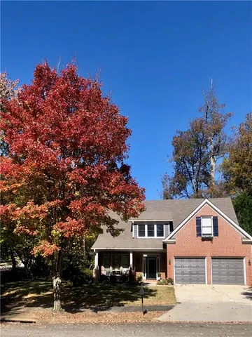 a front view of a house with a tree