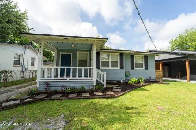 a view of a house with backyard and porch