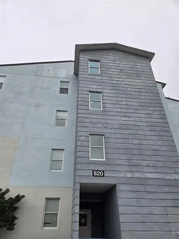 a brick building with a bench next to a road