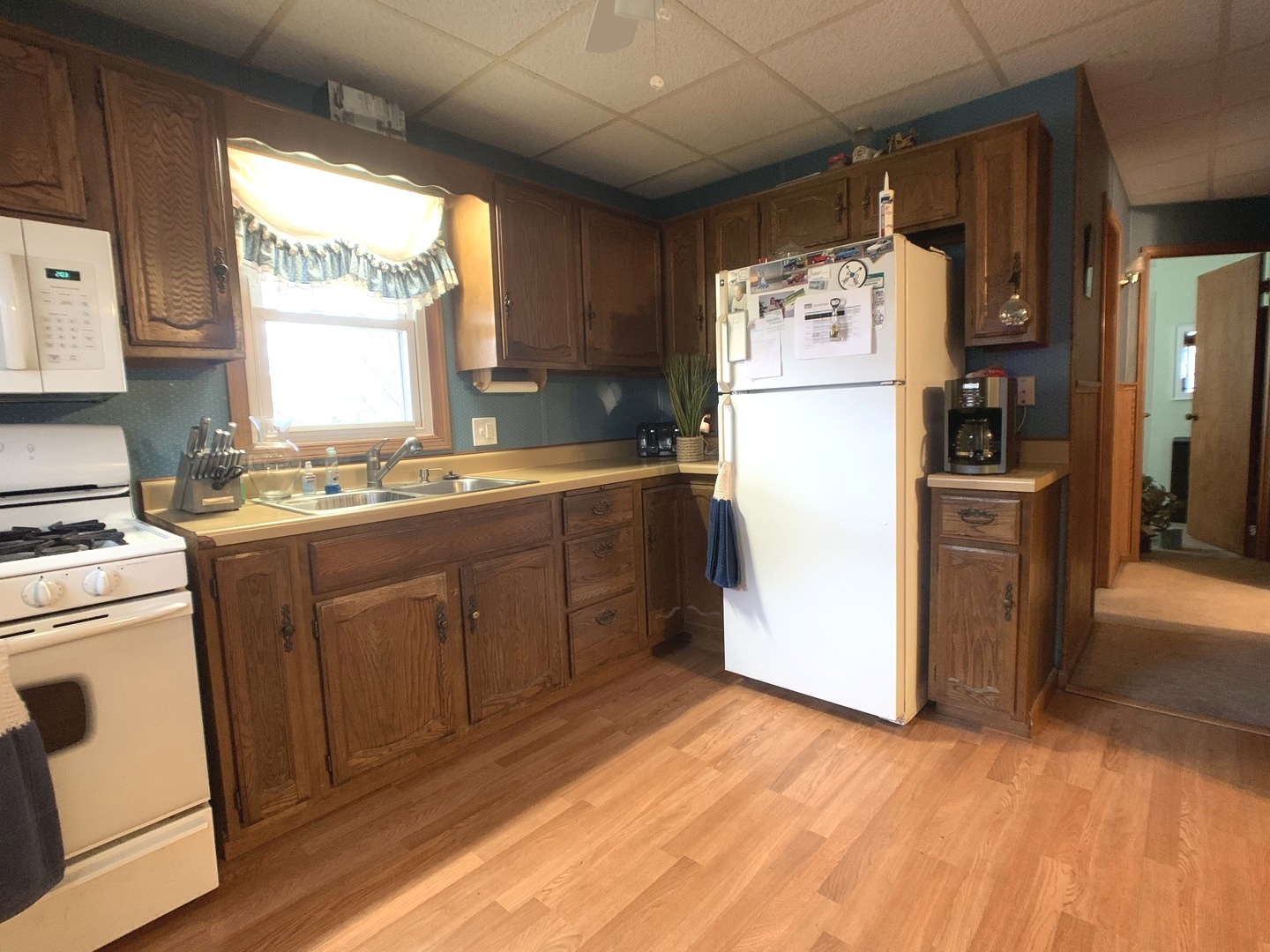 608 West Cleveland Street Spring Valley, IL 61362 - Photo 12 of 35 a kitchen with a refrigerator a stove a sink and white cabinets with wooden floor