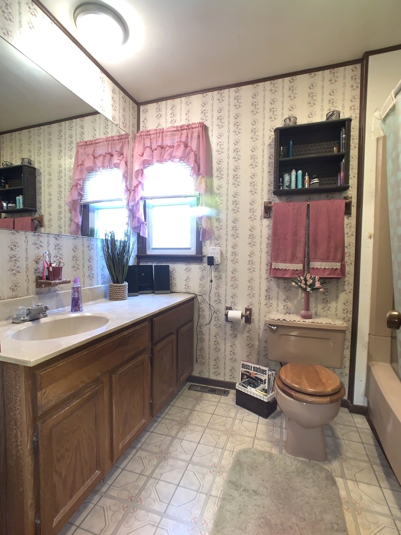 608 West Cleveland Street Spring Valley, IL 61362 - Photo 17 of 35 a bathroom with a granite countertop sink toilet mirror and bathtub