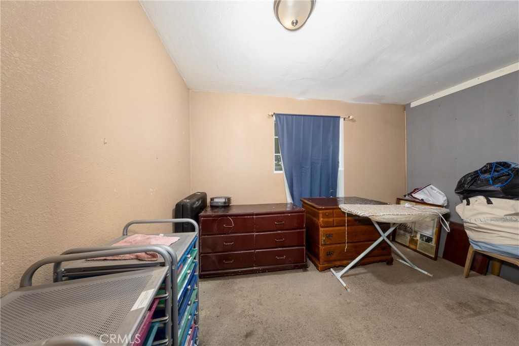 566 South Sage Avenue Rialto, CA 92376 - Photo 22 of 28 a room with a desk and a closet