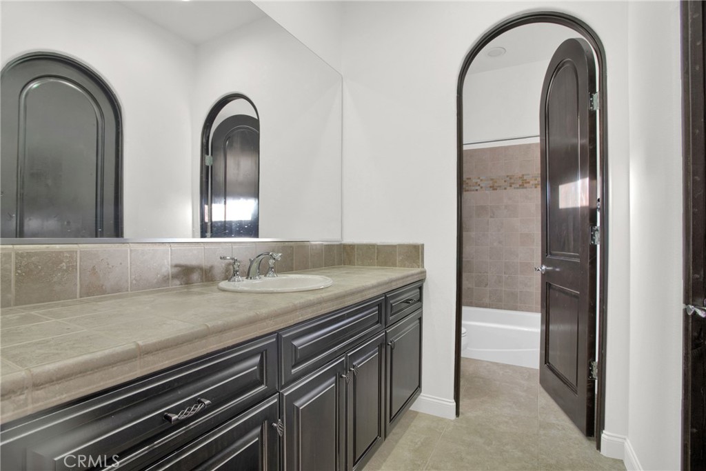 6 Cassis Circle Rancho Mirage, CA 92270 - Photo 47 of 74 a bathroom with a granite countertop sink a mirror and vanity