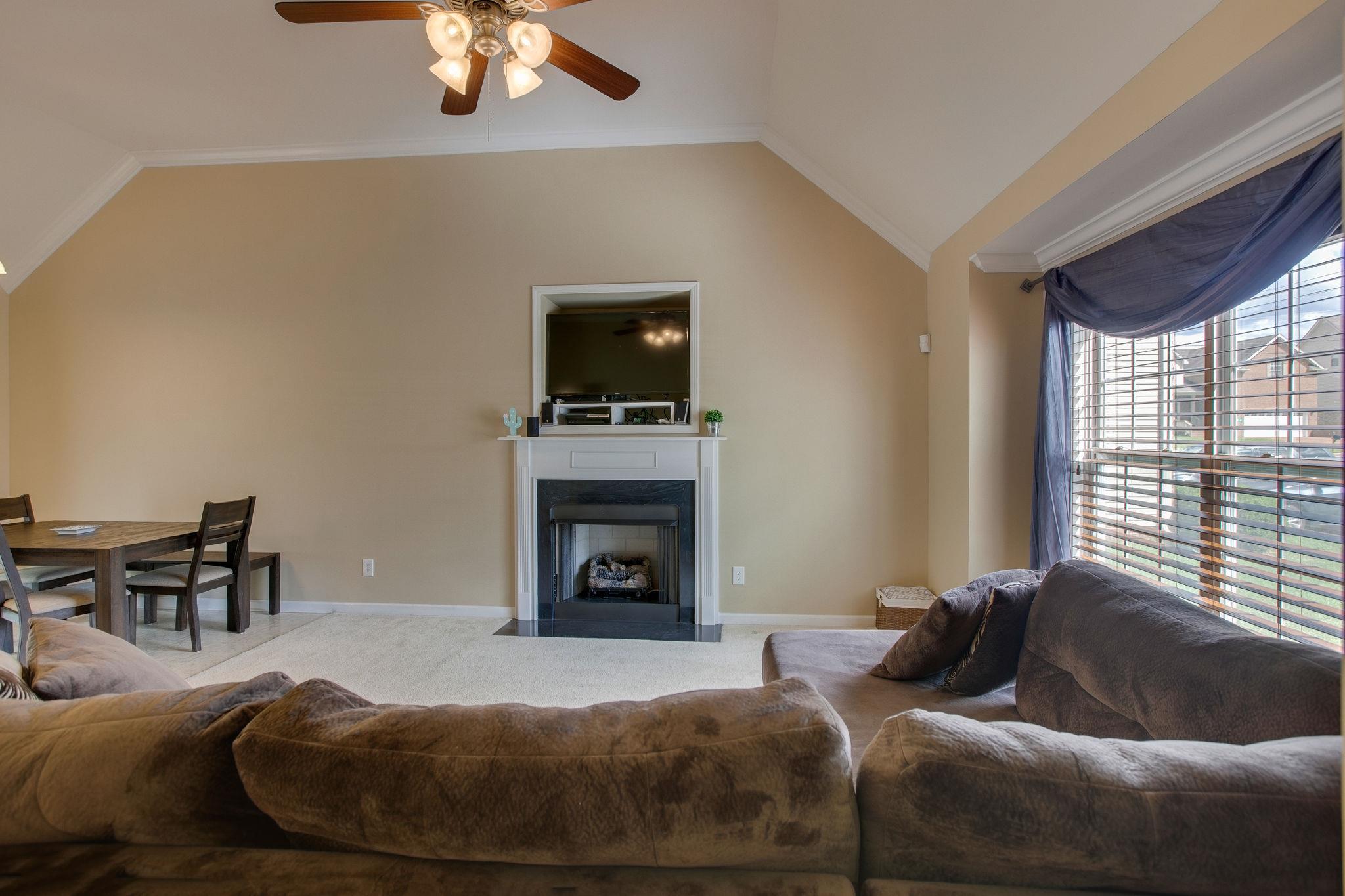 1046 Golf View Way Spring Hill, TN 37174 - Photo 5 of 22 a living room with furniture a fireplace and a flat screen tv