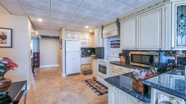 a kitchen with stainless steel appliances granite countertop a stove refrigerator and microwave