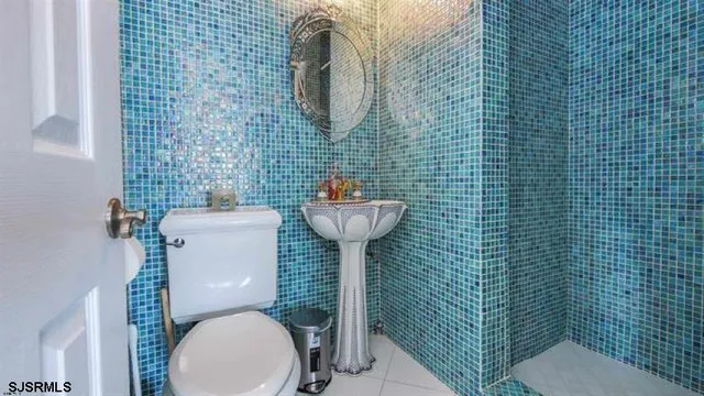 a bathroom with a toilet sink and mirror