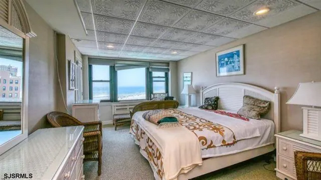 a bedroom with a bed and a large window