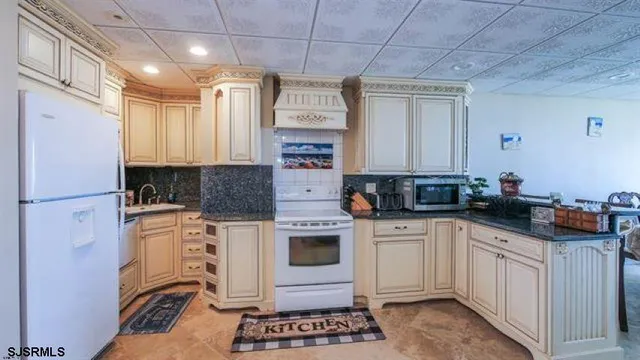 a kitchen with stainless steel appliances a stove a sink and white cabinets