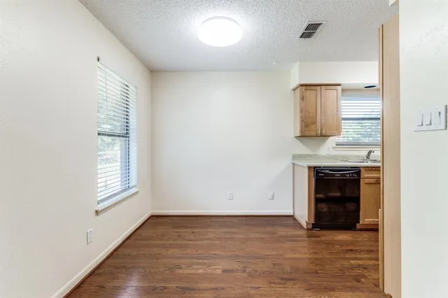 a view of an empty room with a window and fireplace