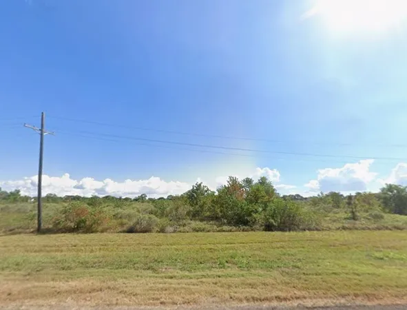 a view of a lake in middle of a field