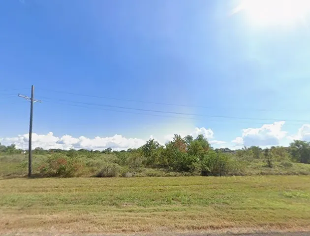 a view of a lake in middle of a field