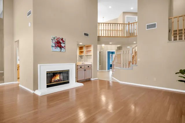 a view of a livingroom with wooden floor and a fireplace