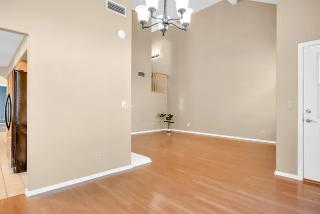 an empty room with wooden floor and bathroom