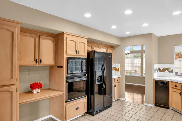 a kitchen with stainless steel appliances kitchen island granite countertop a refrigerator and a sink