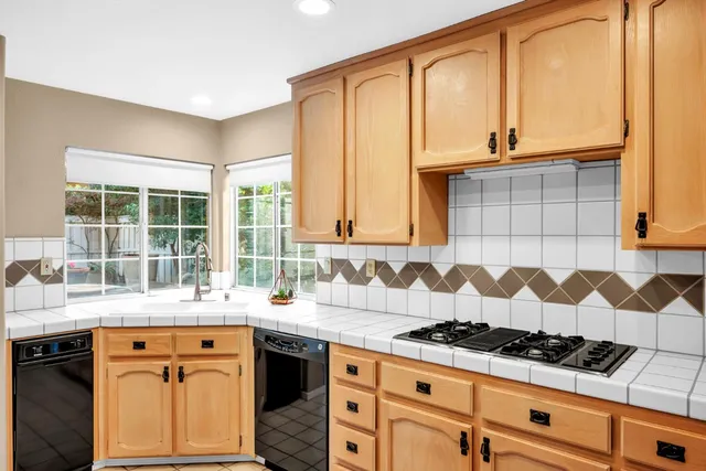 a kitchen with granite countertop a sink a stove and cabinets