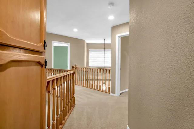 a view of a hallway with wooden floor and windows