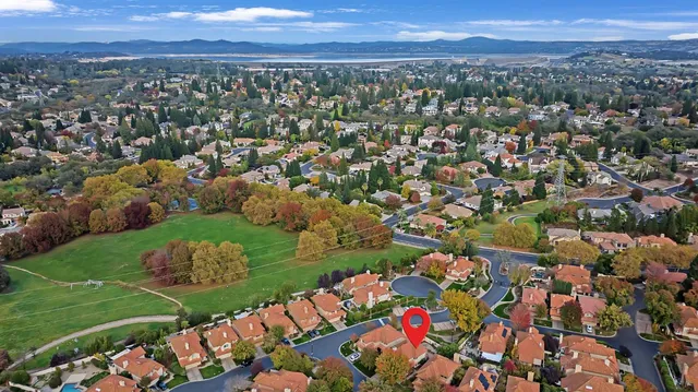 an aerial view of a city with lots of residential buildings and mountain view in back