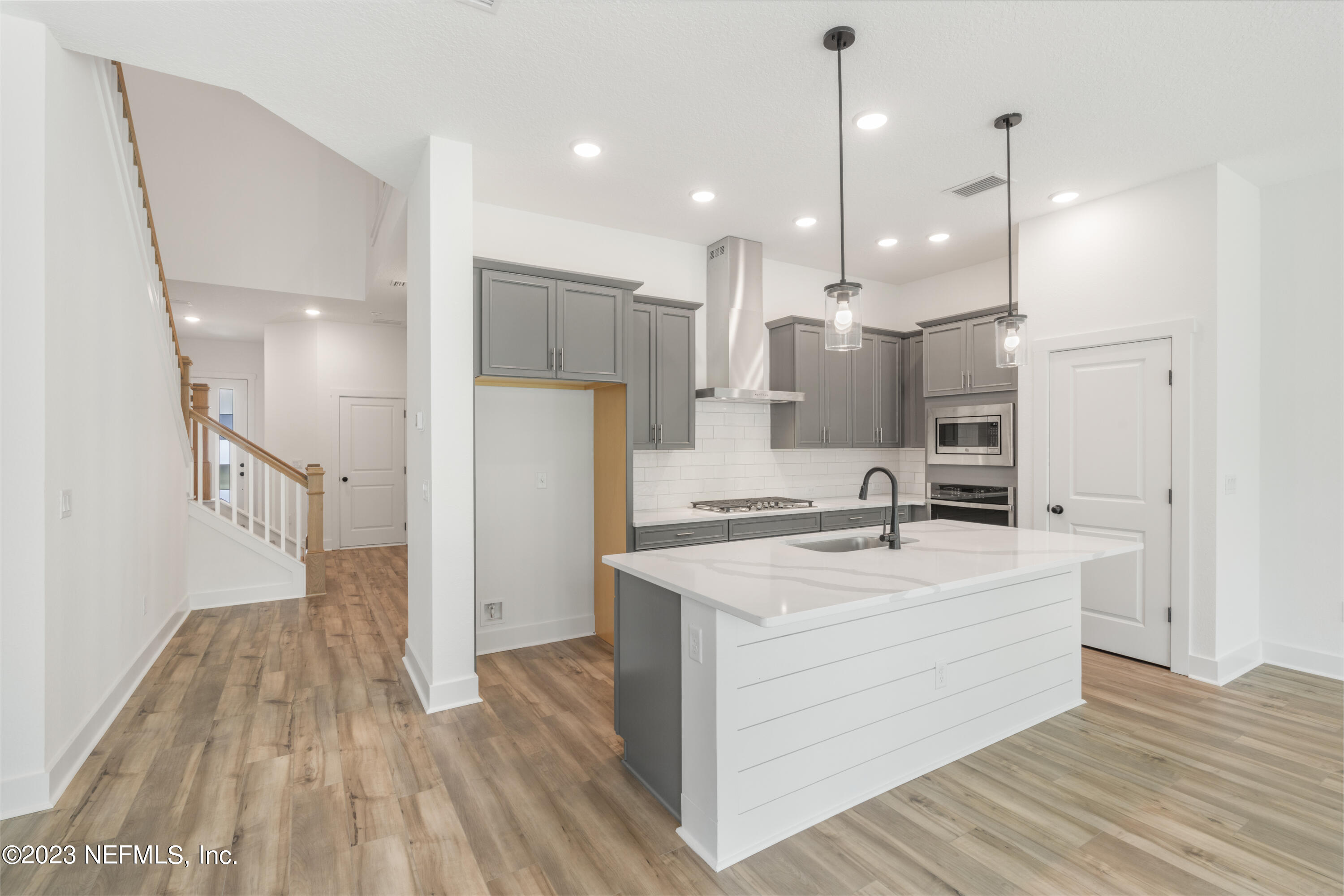 9993 Element Road Jacksonville, FL 32256 - Photo 5 of 11 a open kitchen with a refrigerator a sink dishwasher and a wooden floor