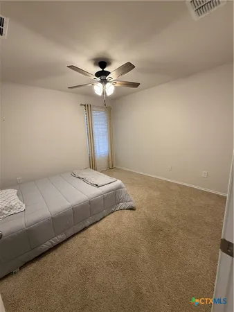 a bedroom with a bed and a ceiling fan