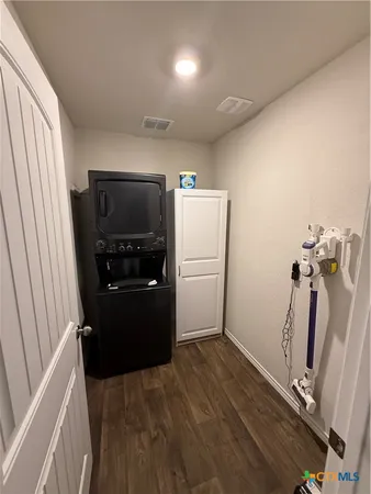 a view of a storage & utility room with a refrigerator