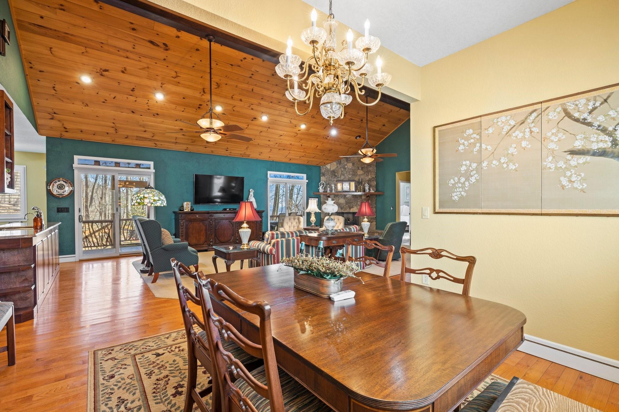 400 The High Road Waynesville, NC 28786 - Photo 18 of 36 a dining room with wooden floor a chandelier a glass table and chairs