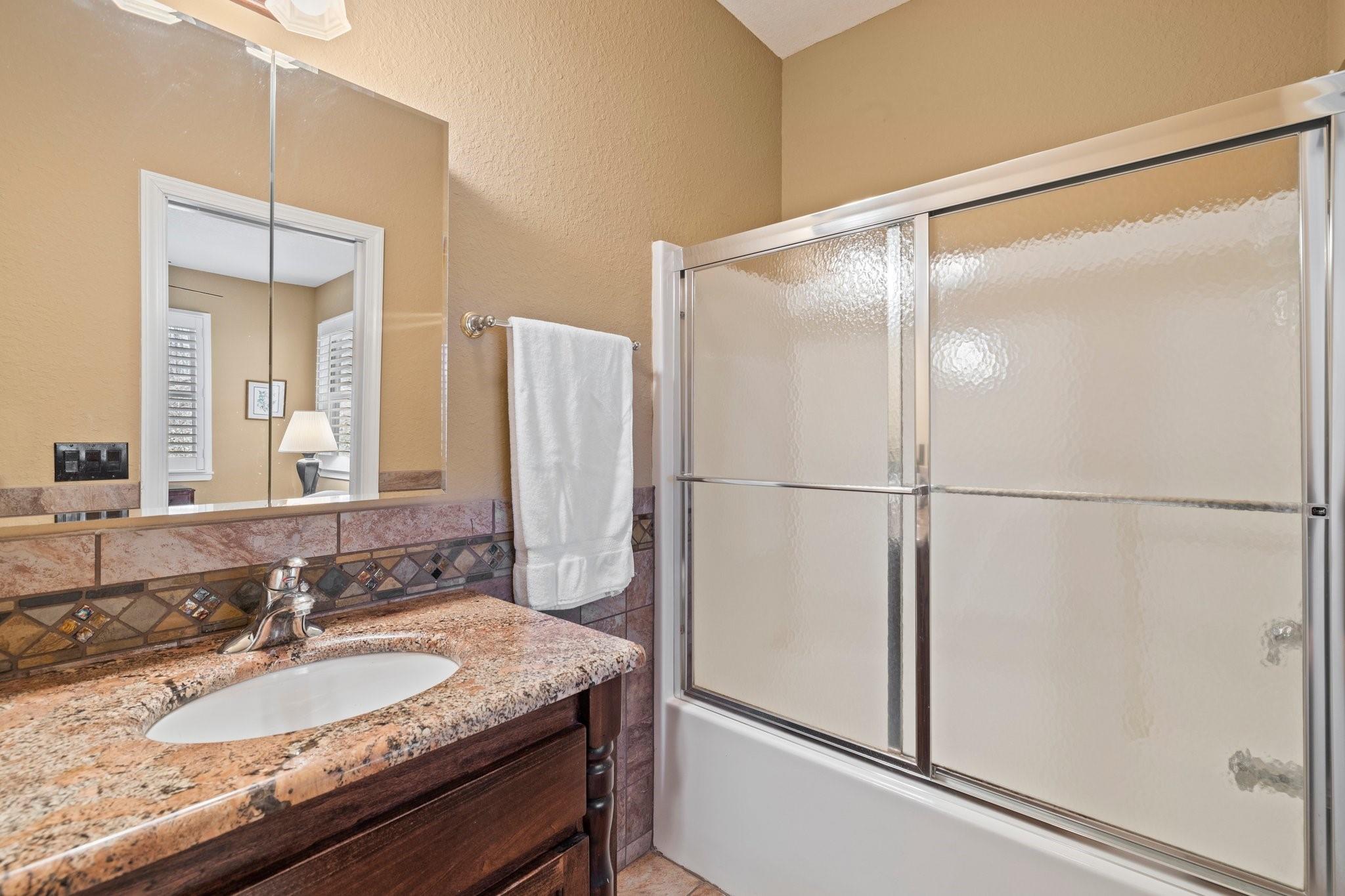 400 The High Road Waynesville, NC 28786 - Photo 28 of 36 a bathroom with a granite countertop sink mirror and a shower