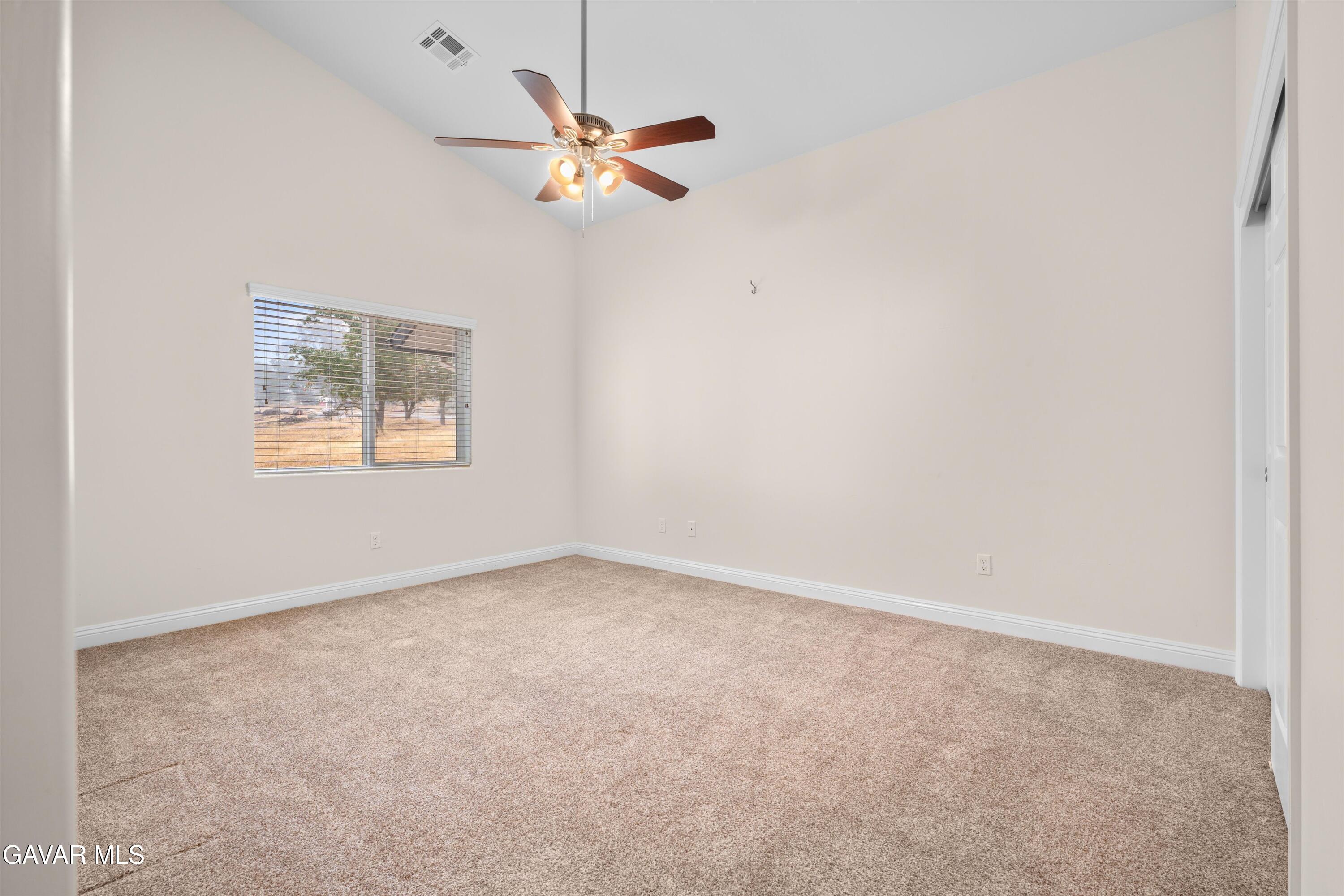17841 Hambletonian Drive Tehachapi, CA 93561 - Photo 9 of 22 an empty room with a chandelier fan and windows