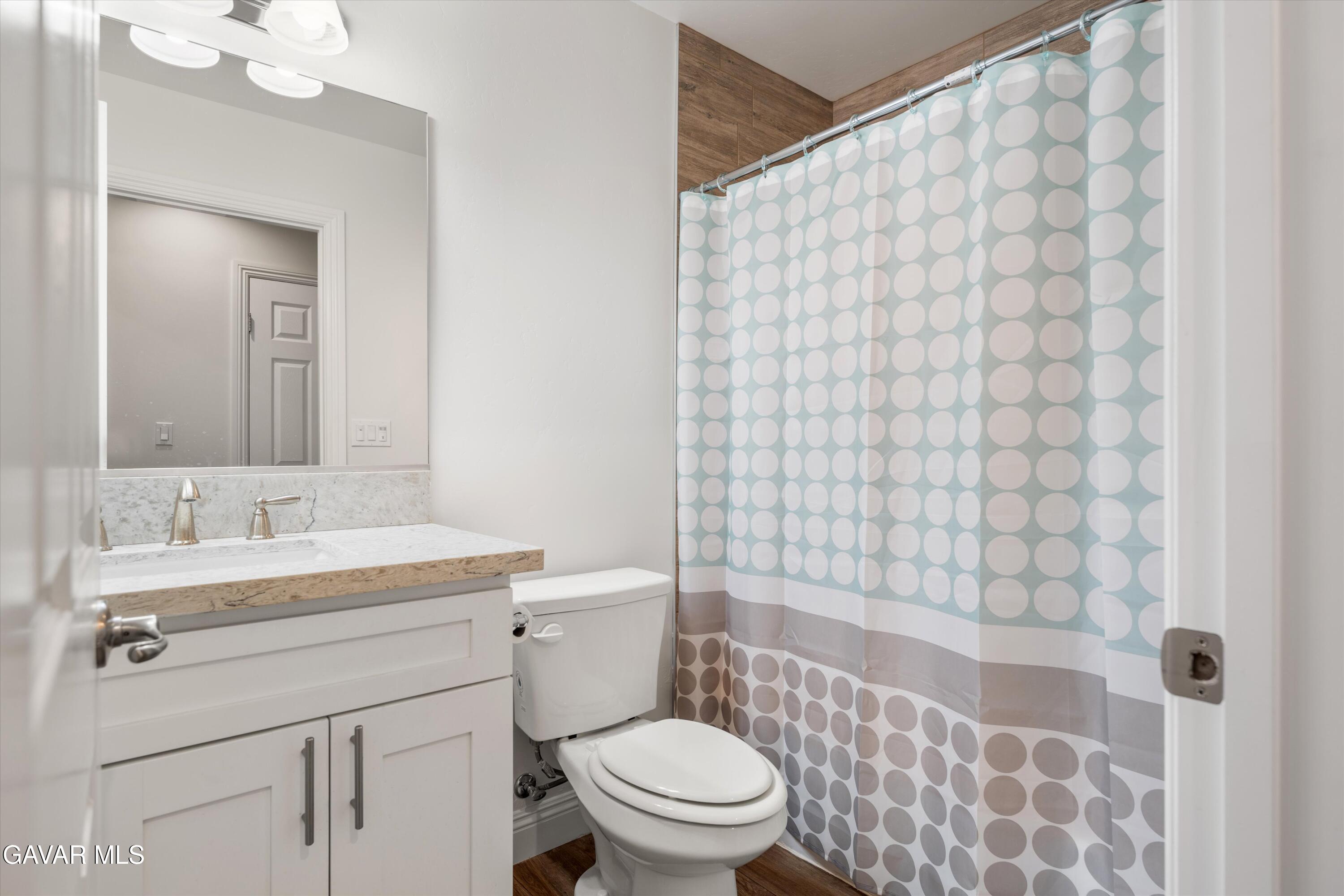 17841 Hambletonian Drive Tehachapi, CA 93561 - Photo 10 of 22 a bathroom with a sink a toilet and shower curtain