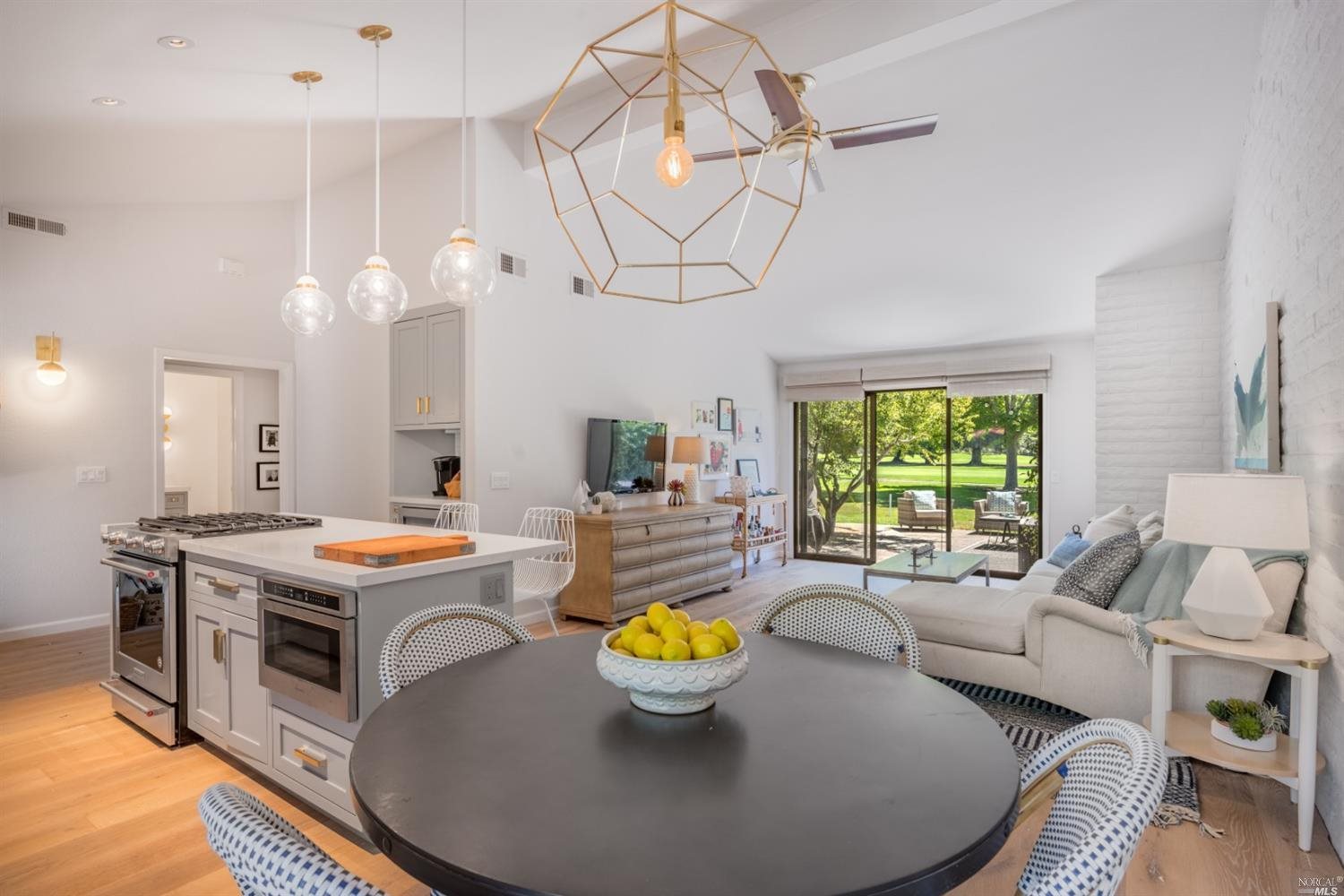 a living room with stainless steel appliances furniture and a chandelier