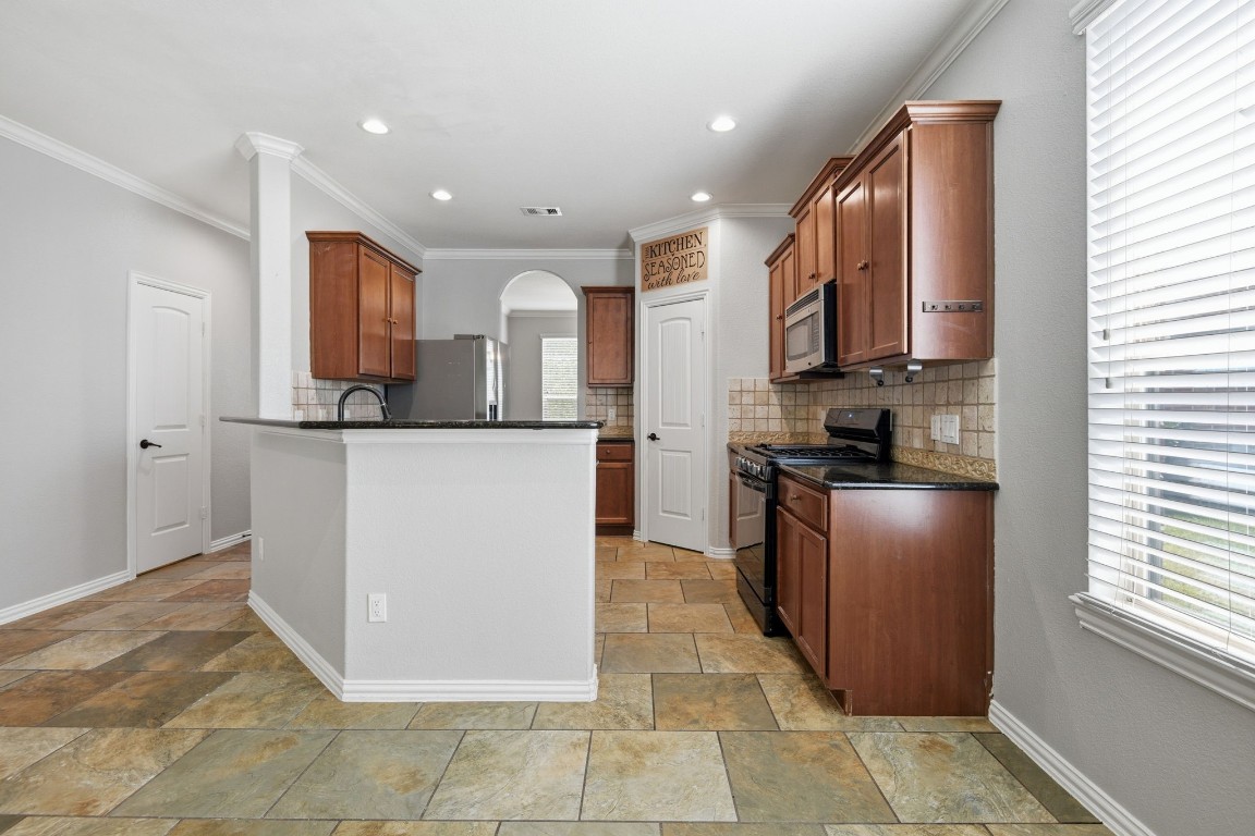 7 Maple Mill Court Conroe, TX 77301 - Photo 5 of 20 a kitchen with stainless steel appliances granite countertop a refrigerator a stove and a sink