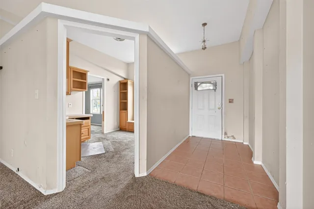 an empty room and a bathroom with mirror