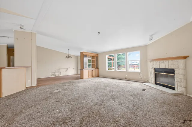 a view of an empty room with a fireplace and a window
