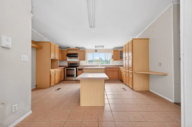 a kitchen with stainless steel appliances granite countertop a refrigerator and a stove top oven