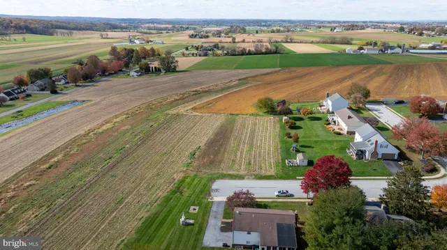 an aerial view of a house with a garden and lake view