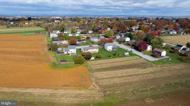 an aerial view of ocean and residential houses with outdoor space