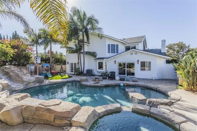 a view of a house with backyard and sitting area